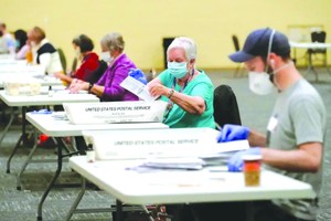 工作人員對郵寄選票進行計數。