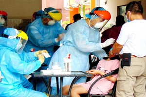 醫護人員正對隔離區域居民採樣以檢測 新冠肺炎病毒。