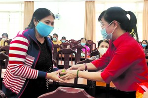 郡婦聯會主席陳氏雪幸(右)向各民族 婦女派發紅包。