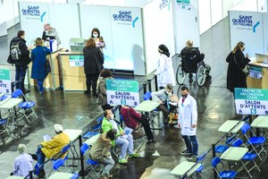 人們在法國一家體育館設立的新冠疫苗接種中心等待接種疫苗。