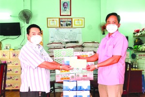 丁文森(左)把物質轉交給阮輝勝書記。