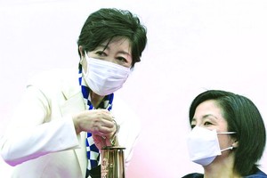 小池百合子(左)接過奧運聖火。