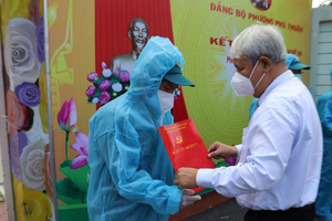 第七郡郡委書記武克泰在富順幼兒園隔離點向新黨員頒發入黨《決定》。