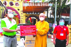 　　第八郡佛教會執行會長釋慧功法師向 郡祖國陣線委員會副主席梅洪峰轉贈物質。