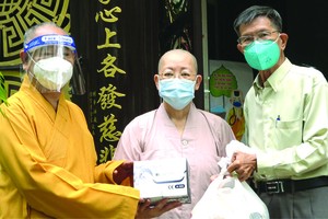 釋慧功和尚、陳健安居士向觀音精舍 監院釋振靜尼師贈送素食品及新冠病毒檢 測用具。