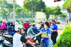 共青團員、青年向民眾派發口罩與 5K 防疫措施傳單。