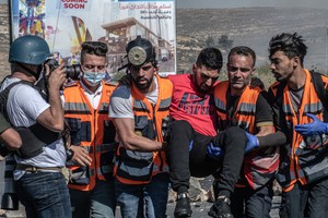 在約旦河西岸的拉馬拉，救援人員正在幫助一名受傷的男子。（圖源：互聯網） 