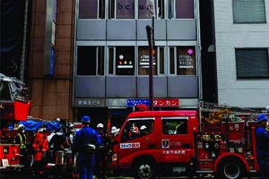 消防員在日本大阪市火災現場附近工作。