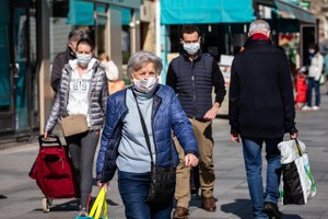 在法國巴黎，人們戴口罩外出。