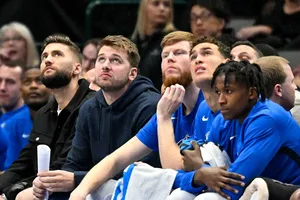 Doncic (áo đen) đang theo dõi một trận đấu của đội nhà trên băng ghế dự bị