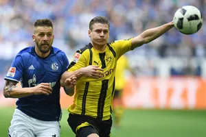 Lukasz Piszczek (phải, Dortmund) tranh bóng với Guido Burgstaller (Schalke). Ảnh: Getty Images.