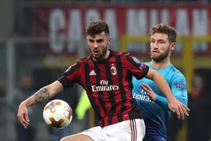 Patrick Cutrone (trái, AC Milan) tranh bóng với Shkodran Mustafi (Arsenal)