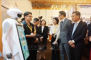 胡志明市人委会副主席阮文勇与各代表观展。