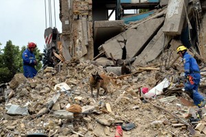 救援人员在乌克兰基辅市索洛缅斯基区遭空袭的居民楼寻找幸存者。