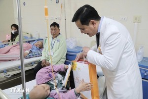 K医院领导向正在接受治疗的患者赠送礼物。