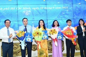 胡志明市人委会主席阮文得和副主席陈氏妙翠向获得委任的个人颁授决定和赠送鲜花表示祝贺。