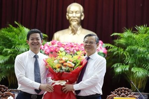 芹苴市委书记黎光松（左）赠送鲜花，祝贺张景宣同志当选芹苴市人委会主席。