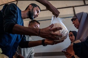 加沙努赛拉特的一家面包房正在分发面包。