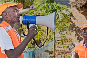 莫桑比克赞比西亚省利昆戈河畔的一名地方减灾委员会成员向村民传达早期预警信息。