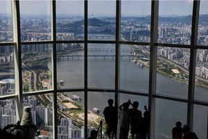 9月5日，游客在首尔的乐天世界塔的高层展望台俯瞰首尔的汉江。
