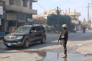 叙利亚安全部队人员在拉塔基亚省杰卜莱的街道上执勤。