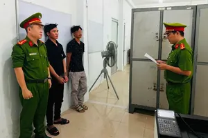 公安对嫌疑人阮文松英宣读暂拘令。