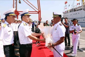 越南海军第二区司令部副参谋长黎廷宜大校（左）向KRI Bima Suci号船长苏庚·哈里扬托中校送花欢迎。