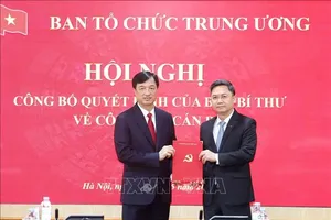 党中央政治局委员、党中央书记处书记、中央组织部部长阮维玉向何明海同志颁发党中央书记处的决定。