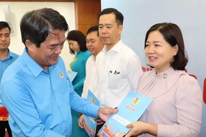 胡志明市劳动联团主席裴清仁向各坊、乡、特区党委移交已签署的配合规制。