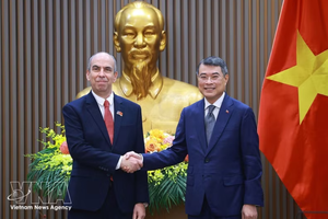 越南政府总理黎明兴与古巴共和国驻越南特命全权大使罗赫略·波兰科·富恩特斯亲切握手。