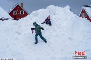 格陵兰岛努克，孩子们在新雪上玩耍。