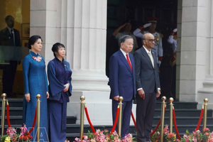 党中央总书记、国家主席苏林与新加坡总统尚达曼在检阅台上，聆听军乐队奏两国国歌。