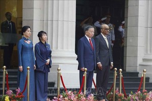 党中央总书记、国家主席苏林和新加坡总统尚达曼在荣誉台上，聆听军乐队奏两国国歌。图源：统一/越通社。