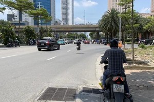 在河内杨廷艺街与环市三路四岔路口等待交通信号灯的交通参与者在树荫下停车躲避烈日。图：福厚