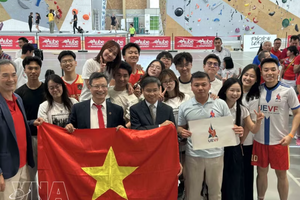 越南驻法国大使郑德海与参会的青年协会成员合影。图自越通社