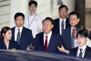 2025年7月9日晚，韩国前总统尹锡悦接受讯问后走出首尔中央地方法院。图源：新华社