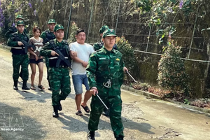 老街国际口岸边防部队押解“LC326”专案2名涉嫌贩运人口犯罪嫌疑人。图片来源：越通社
