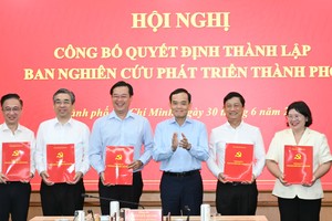胡志明市市委书记、胡志明市发展研究处主任陈留光向胡志明市发展研究处各位副主任同志颁授决定。图：越勇