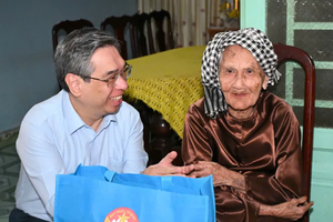 胡志明市市委副书记阮福禄问候阮氏昱母亲的健康状况。图：越勇