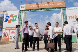 胡志明市市委副书记邓明通与工作团视察FPT教育综合项目施工进度。图：黄雄