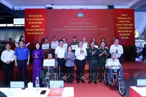 胡志明市市委副书记、市越南祖国阵线委员会主席阮福禄（右四）向优抚政策家庭赠送车辆、谋生工具。