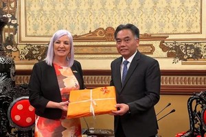澳大利亚北领地贸易、商业和亚洲关系部长卡希尔向胡志明市人委会常务副主席阮禄河赠送纪念品。图：明春