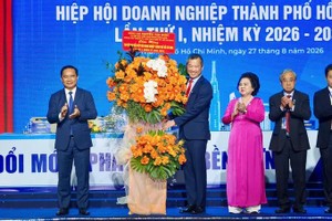 胡志明市人委会主席阮文得向胡志明市企业联合会执委会赠花。图：黄雄