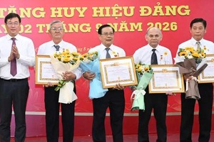 胡志明市市委常务副书记黎国峰向高龄党员颁授党龄纪念章。图：越勇
