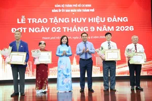 胡志明市人委会党委书记、市人委会主席阮文得与胡志明市人委会党委副书记阮青春颁授党龄纪念章。图：黎妥