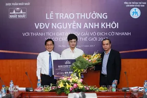 Anh Khôi (giữa) được Liên đoàn cờ và nhà tài trợ thưởng 69 triệu đồng. Ảnh: NGỌC HẢI