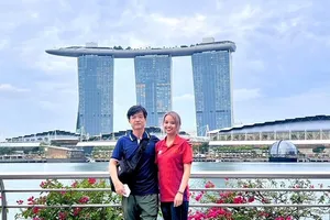 Tuyển thủ Ánh Nguyệt và chuyên gia Hàn Quốc của đội tuyển bắn cung Việt Nam chụp ảnh lưu niệm trước khi sẵn sàng bước vào tranh tài ở Singapore. Ảnh: A.NGUYỆT