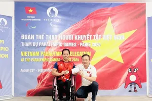 Lực sỹ Lê Văn Công được Trưởng đoàn Nguyễn Hồng Minh trao thưởng "nóng" 50 triệu đồng. Ảnh: CỤCTDTT