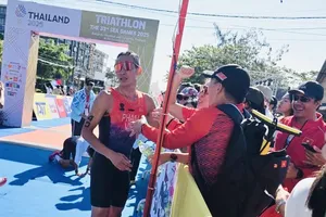 Phạm Tiến Sản được Ban huấn luyện đội tuyển triathlon Việt Nam chúc mừng khi hoàn thành chiến thắng giành HCV. Ảnh: MINH MINH