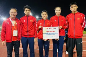 Trưởng đoàn Nguyễn Hồng Minh (ngoài cùng bên trái) động viên VĐV điền kinh Việt Nam giành HCĐ đầu tiên tại ASIAD 20. Ảnh: LƯỢNG LƯỢNG
